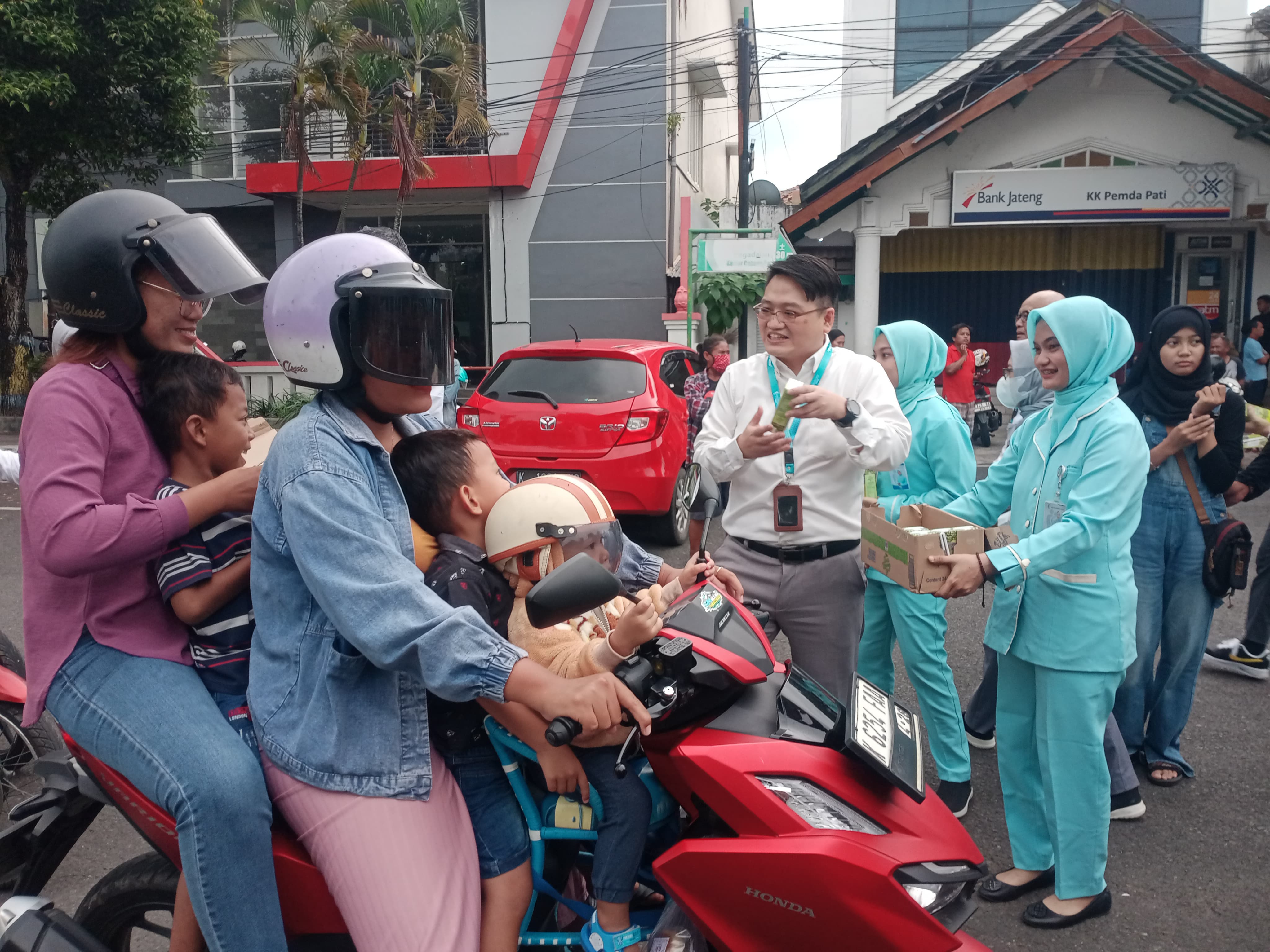 Direktur KSH Pati, Kelvin Kurniawan membagikan minuman kepada warga yang sedang melintas di Alun-Alun Simpanglima Pati. (ACHMAD ULIL ALBAB/RADAR KUDUS)