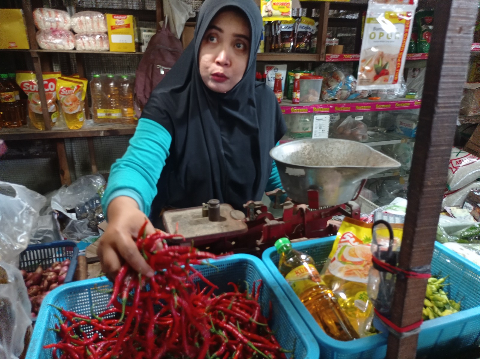 Pedagang di Pasar Rogowongso Pati menunjukkan produk cabai merah yang dijual. (ACHMAD ULIL ALBAB/RADAR KUDUS)