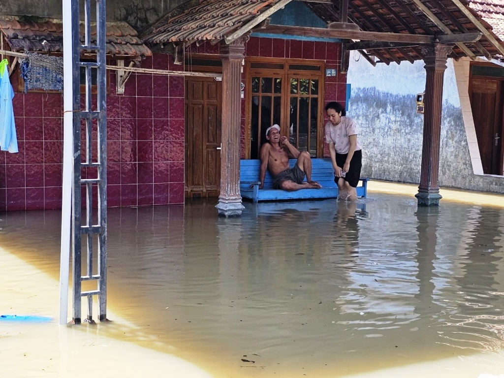 KEBANJIRAN: Warga Desa Ketitangwetan, Batangan bertahan di genangan banjir di kediamannya kemarin.