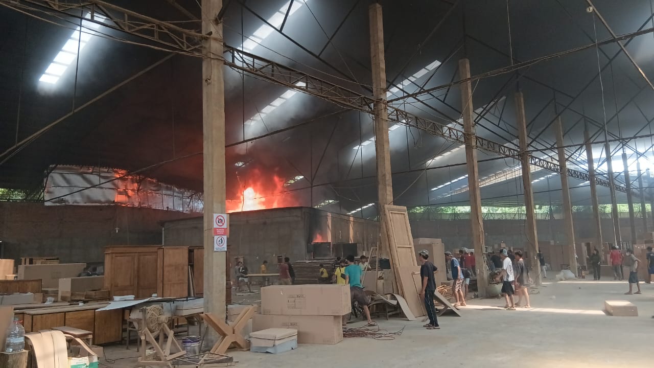 BERKOBAR: Pegawai sebuah gudang mebel di Desa Troso, Pecangaan, berusaha menyelamatkan barang-barangnya dari amukan kebakaran kemarin.