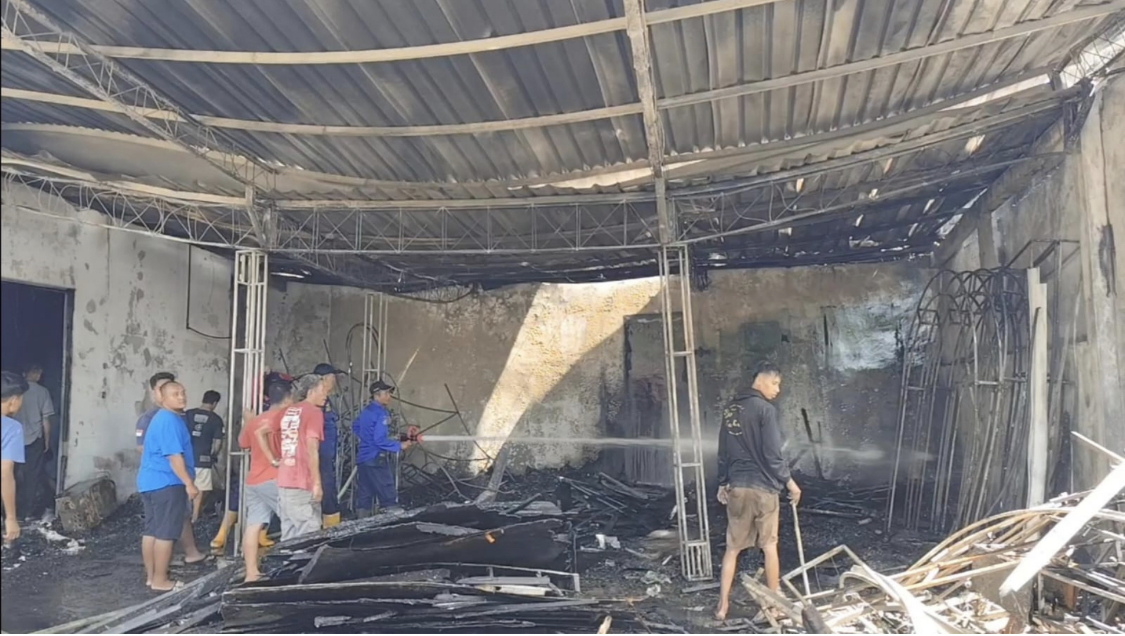 TERBAKAR: Petugas Damkar bersama warga memadamkancapi di gudang Desa Bermi, Gembong kemarin. ANDRE FAIDHIL FALAH/RADARPATI.ID