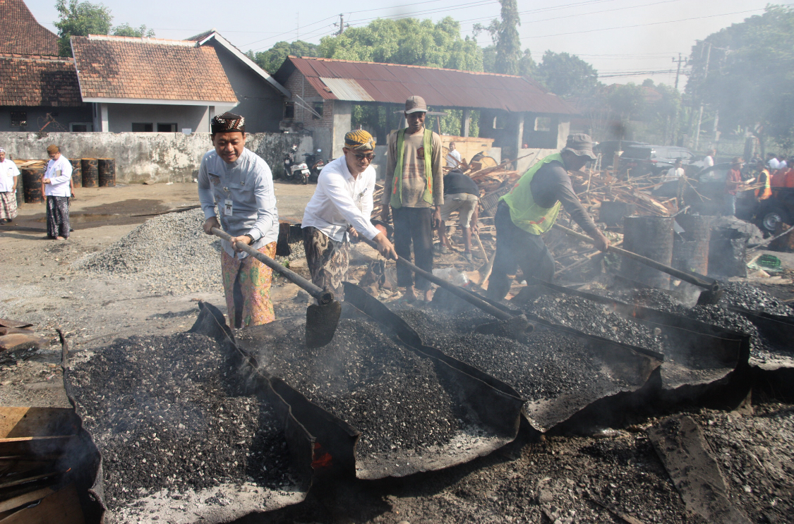 KEWES: Bupati Kudus Samani ikut mengaduk aspal bersama petugas untuk menambah jalan Kudus yang rusak. DONNY SETYAWAN/RADARPATI.ID