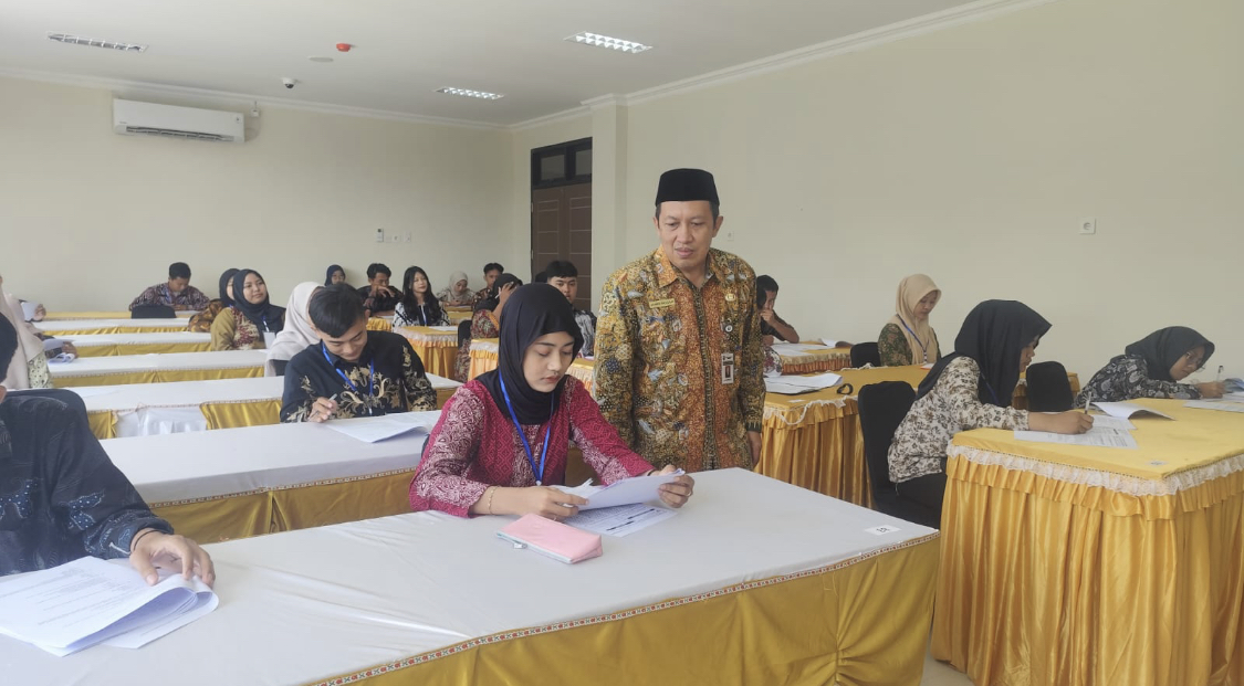 SERIUS: Kepala Dinarpus Ahmad Sholchan meninjau pelaksaan tes tertulis 95 peserta yang ikuti pemilihan Duta Literasi di Perpusda kemarin. PEMKAB RBG UNTUK RADARPATI.ID
