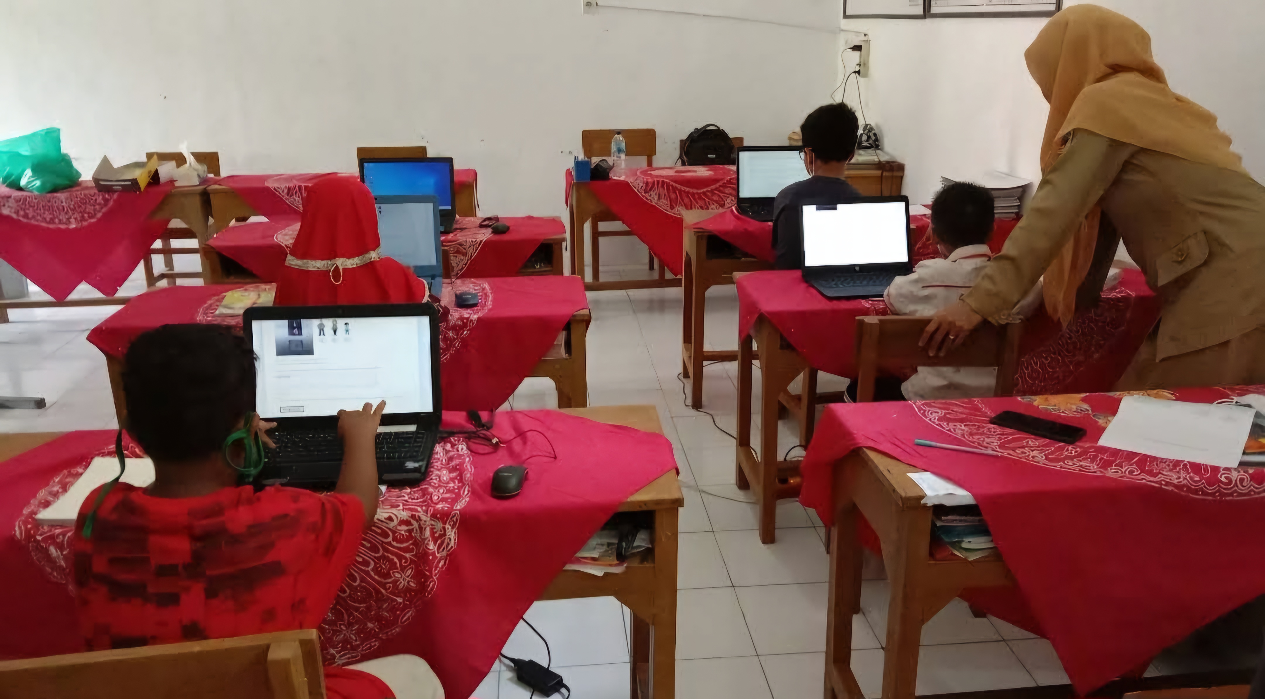 MENGAJAR: Seorang Guru Sedang Mengajar Pelajaran TIK di Sekolah