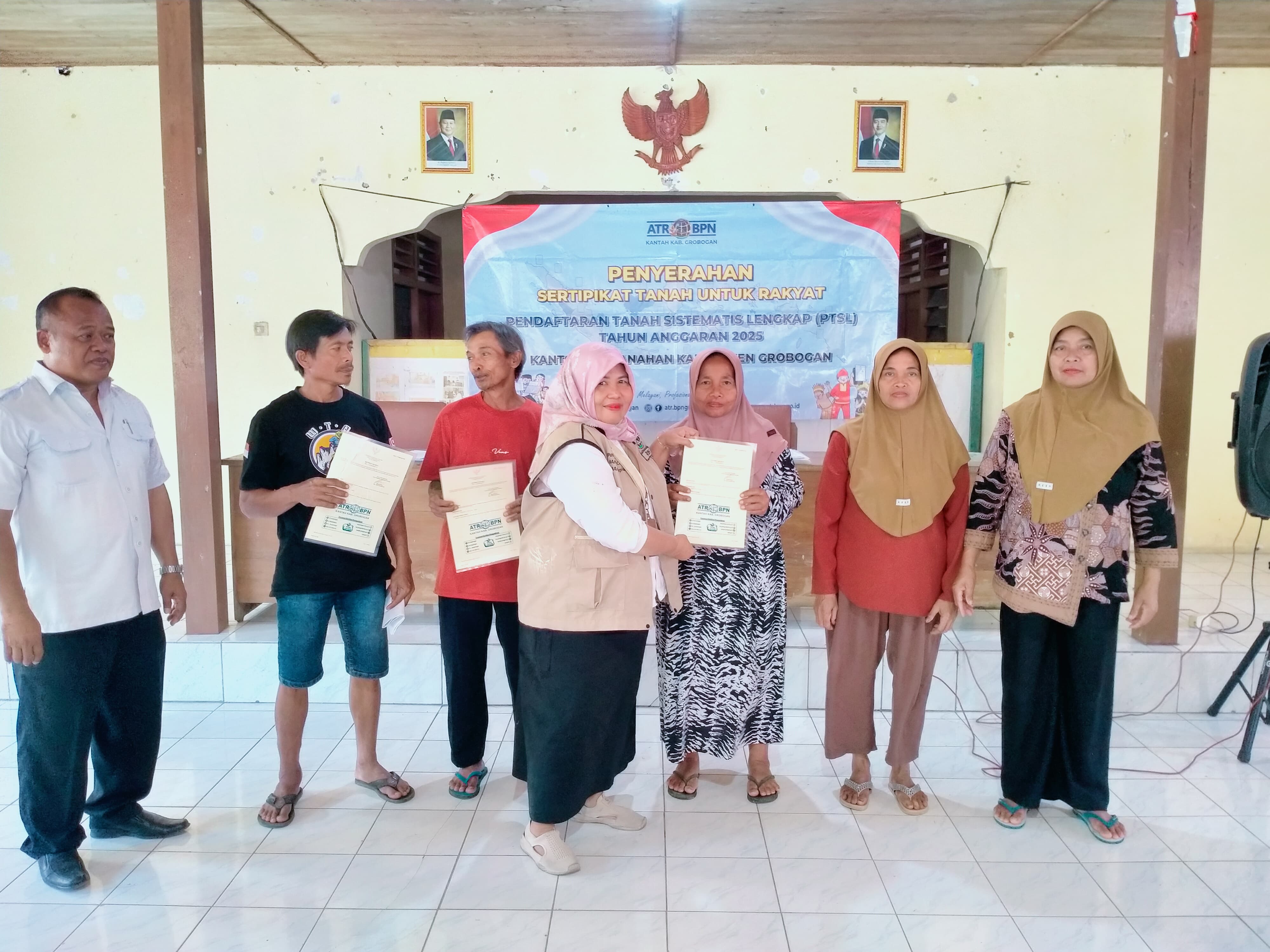 DISERAHKAN: Petugas dari Kantah Grobogan saat menyerahkan sertifikat PTSL di Desa Kemadohbatur Kecamatan Tawangharjo.