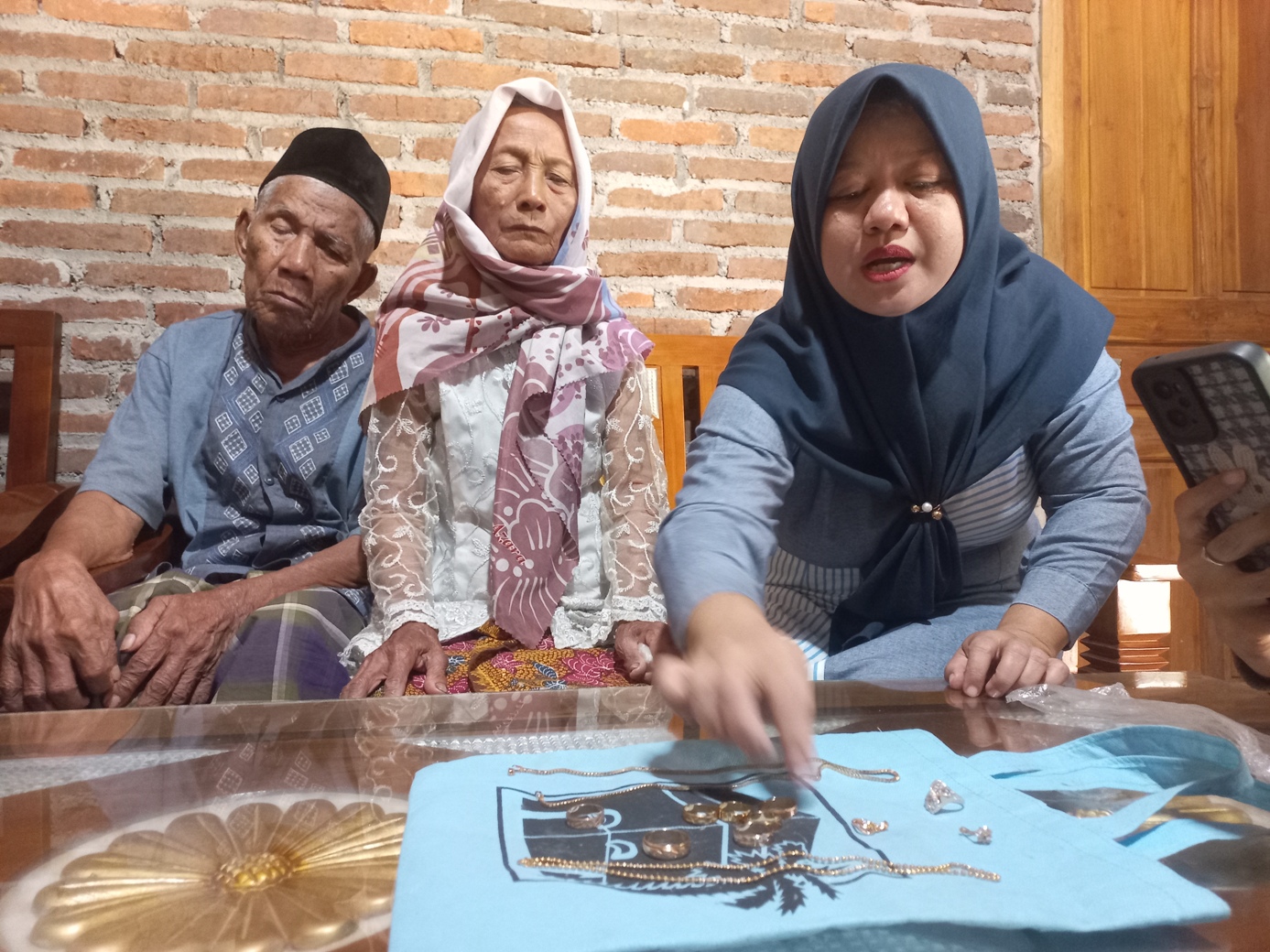 IMITASI: Sukarti didampingi oleh sang suami Suhadi menunjukkan perhiasan simpanannya yang berubah jadi mainan Senin (21/7).