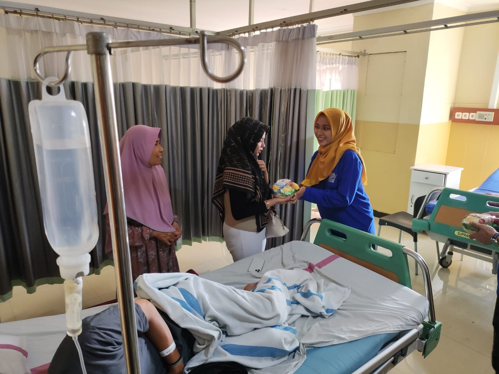 BERBAGI KEBAHAGIAAN: Direktur RS Aisyiyah Kudus, dr Indah Rosiana membagikan bingkisan kepada para keluarga pasien.