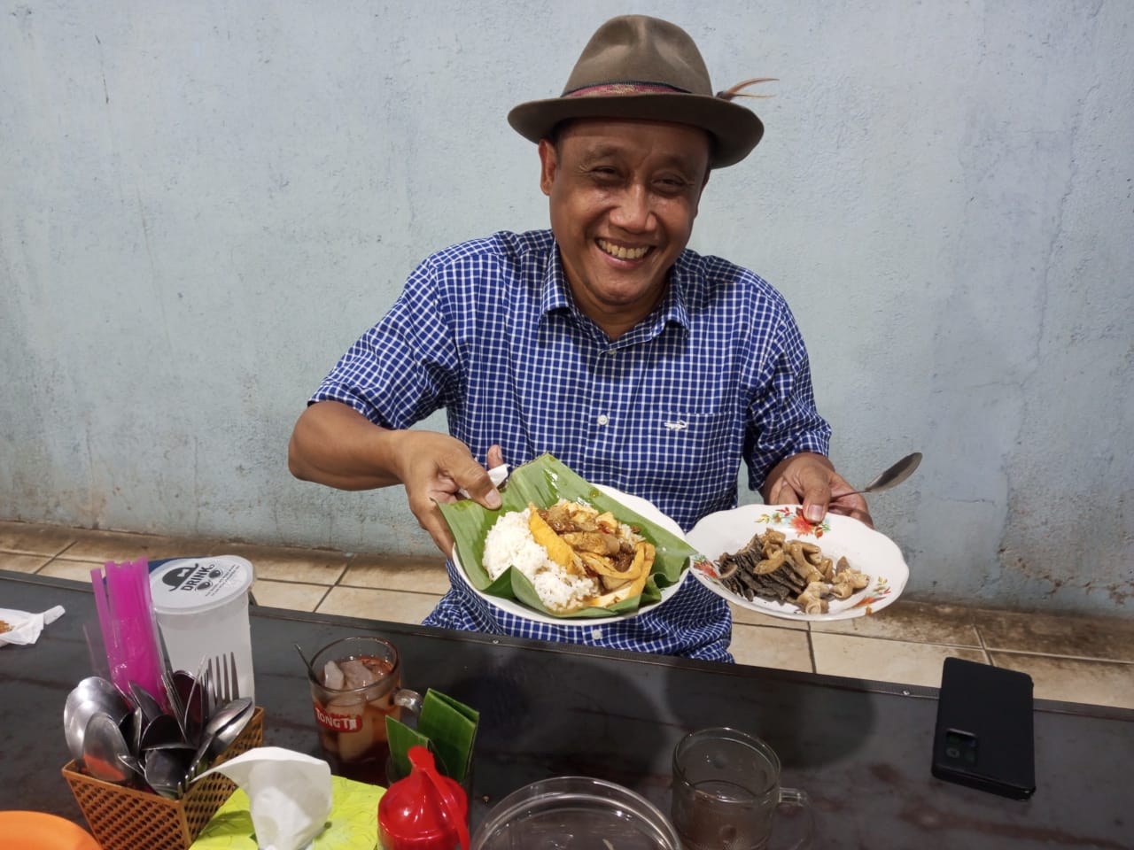 Saiful Arifin menunjukkan kuliner nasi tahu di salah satu warung di Desa Ngemplak Margoyoso Pati. (ACHMAD ULIL ALBAB/RADAR PATI)