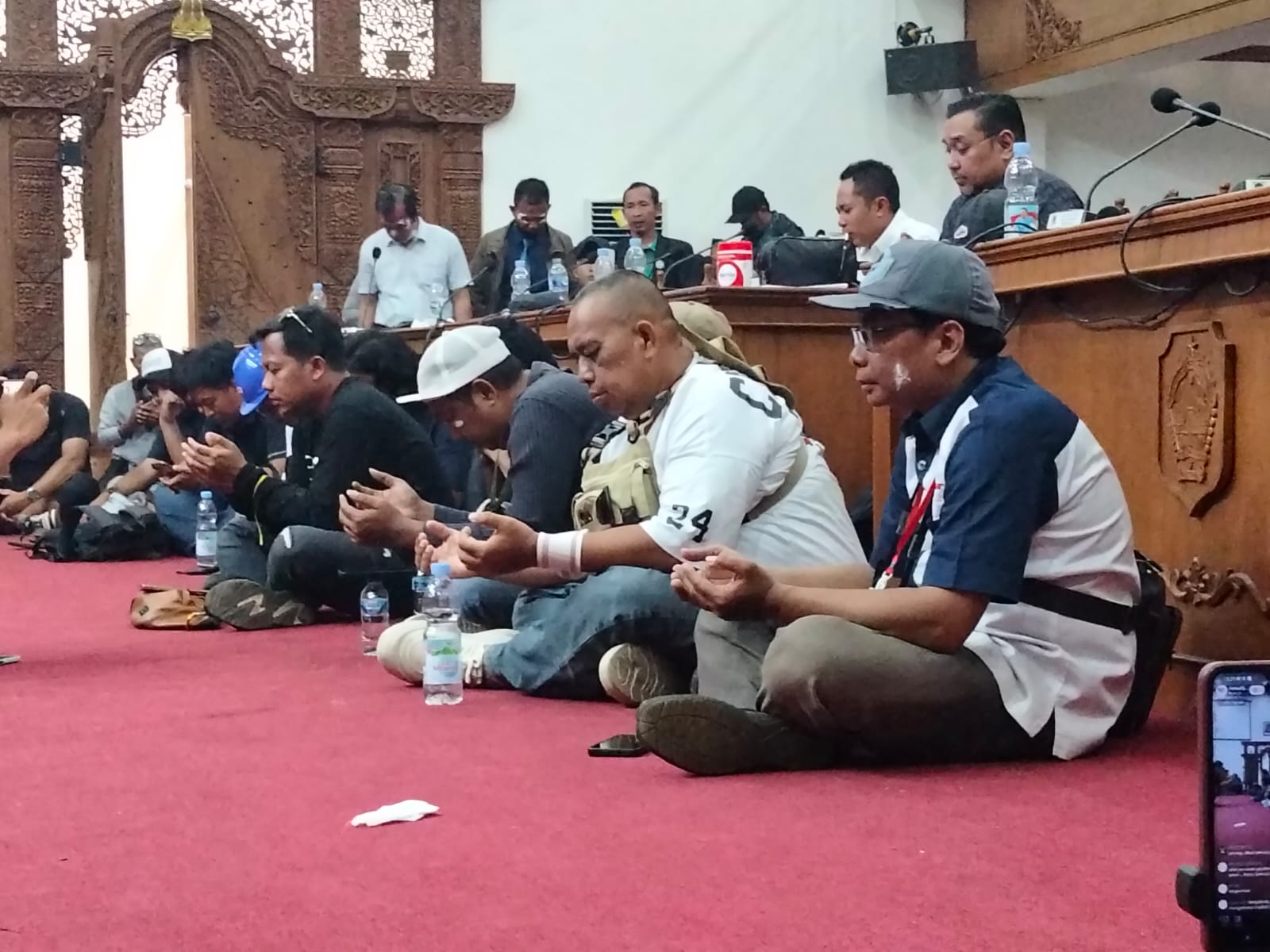 Anggota DPRD Pati dan peserta demo berdoa setelah mendengar kabar dua orang perempuan dan wartawan meninggal dalam demo, Rabu 13/8/2025.