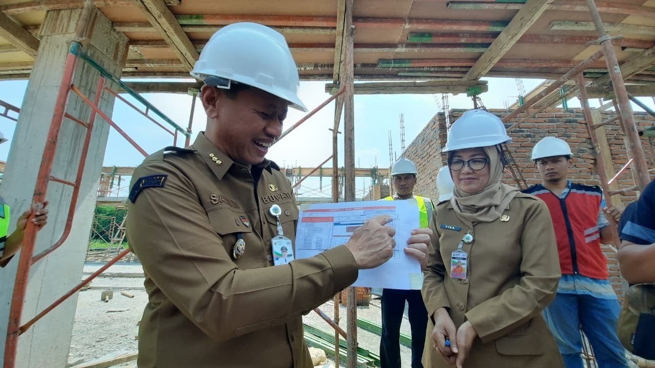 TINJAU PROYEK: Bupati Kudus Samani Intakoris bersama Plt Kadinas Arpus Mutrikah melihat progres pengerjaan Gedung Perpustakaan Daerah kemarin.(INDAH SUSANTI/RADARPATI.ID)