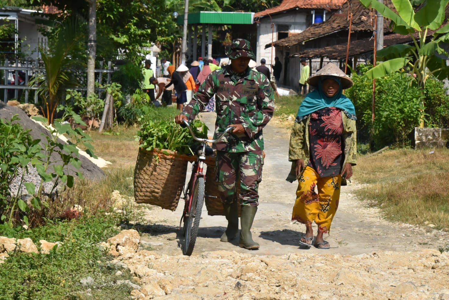 PEDULI: Anggota satgas TMMD saat membantu warga sekitar lokasi TMMD Reguler di Desa Karangharjo Kecamatan Pulokulon.