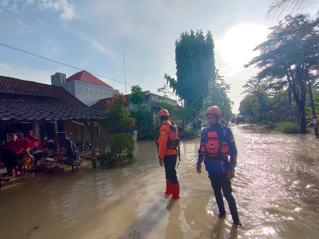 TERGENANG: Petugas BPBD Grobogan berjaga di jalan tergenang untuk membantu pengendara yang melintas.(INTAN M. SABRINA)