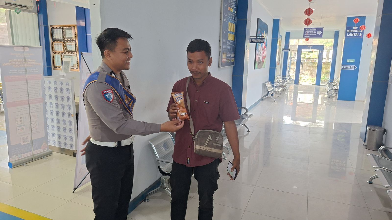 REWARD: Petugas Satlantas Grobogan saat memberikan reward ke pemohon SIM.