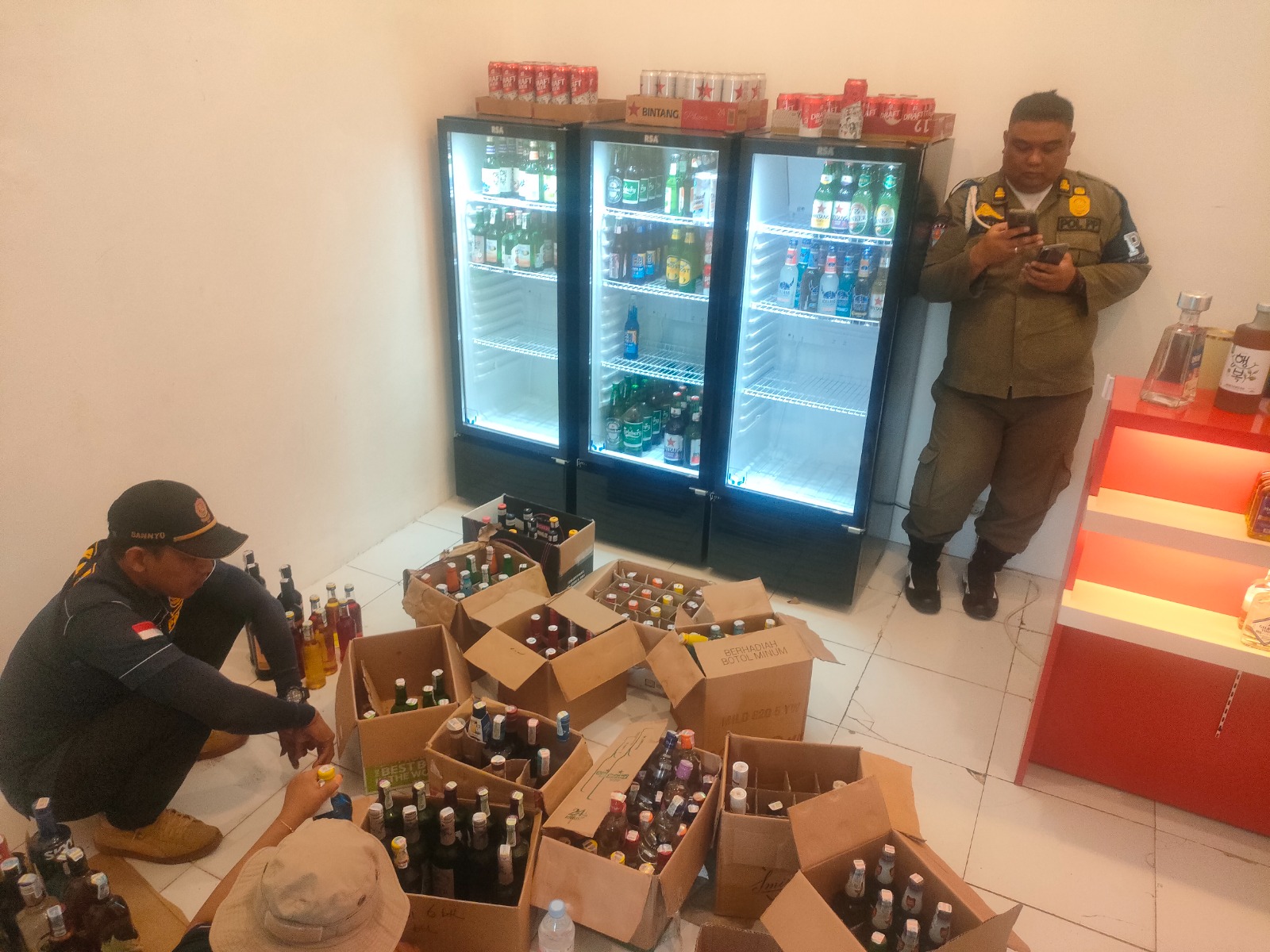 DISITA: Petugas Satpol PP mengamankan puluhan ratusan botol berisi miras di ruko Jalan Pemuda Rembang kemarin.(WISNU AJI/RADAR PATI)