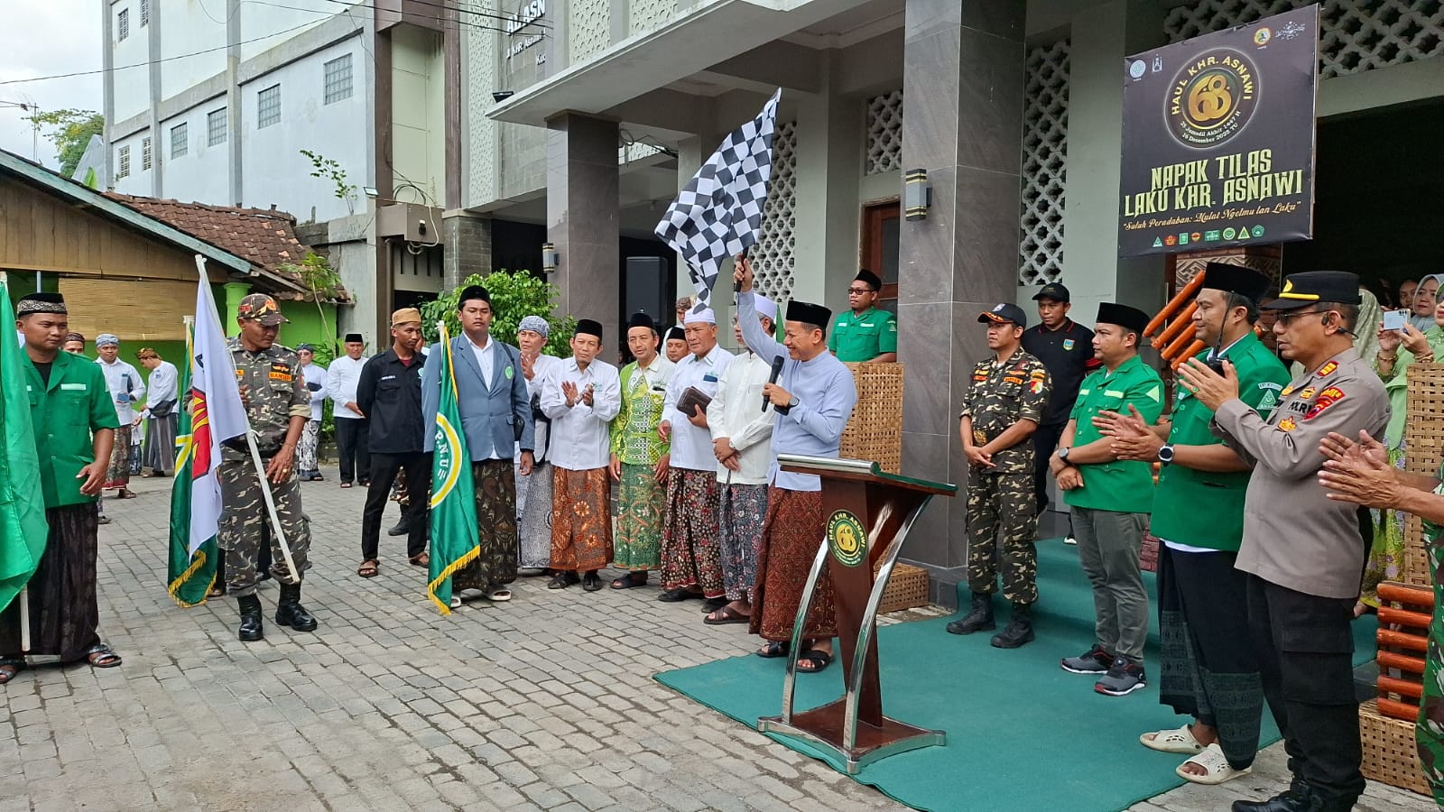 MULAI: Bupati Kudus Sam&rsquo;ani Intakoris mengibarkan bendera start kegiatan Napak Tilas Laku KHR Asnawi di Pondok Pesantren Raudlatut Tholibin Bendan kemarin.
