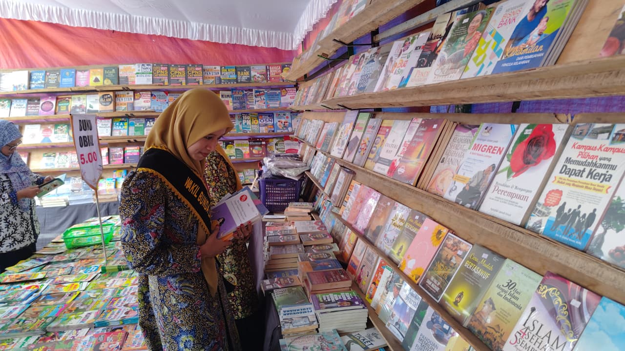 TAMBAH WAWASAN: Pengunjung membaca buku bacaan dalam pameran buku yang digelar Dinarpus Rembang.