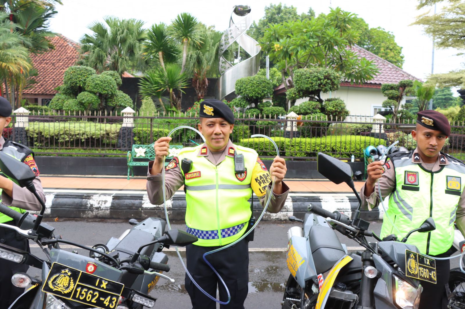 Personel Polres Kudus membawa selang untuk membantu pengendara mogok.