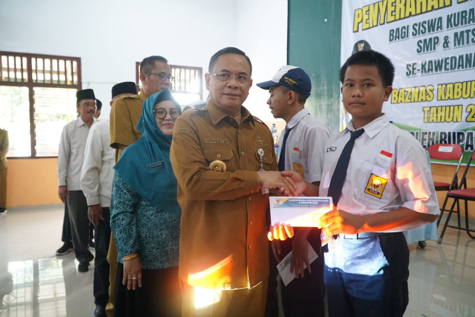 Bupati Sudewo secara simbolis menyerahkan bantuan kepada pelajar tingkat SMP/MTs di eks Kawedanan Pati.  (ACHMAD ULIL ALBAB/RADAR KUDUS)