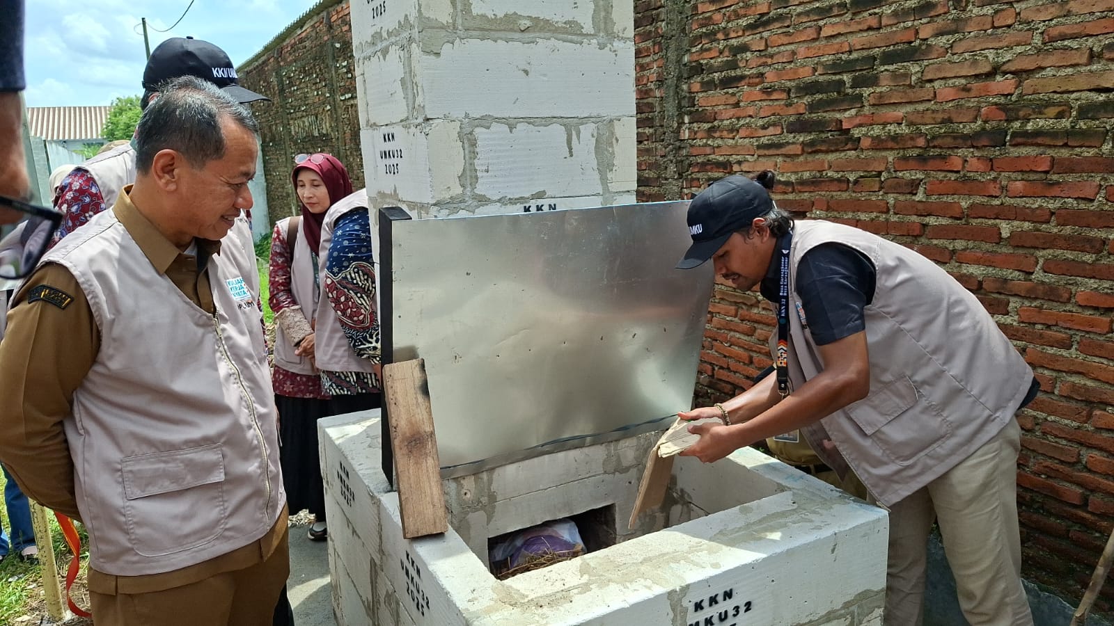 BAKAR: Seorang mahasiswa KKN 32 UMKU menunjukkan cara kerja insinerator sederhana kepada Bupati Kudus dan audiens pada Senin (29/12).