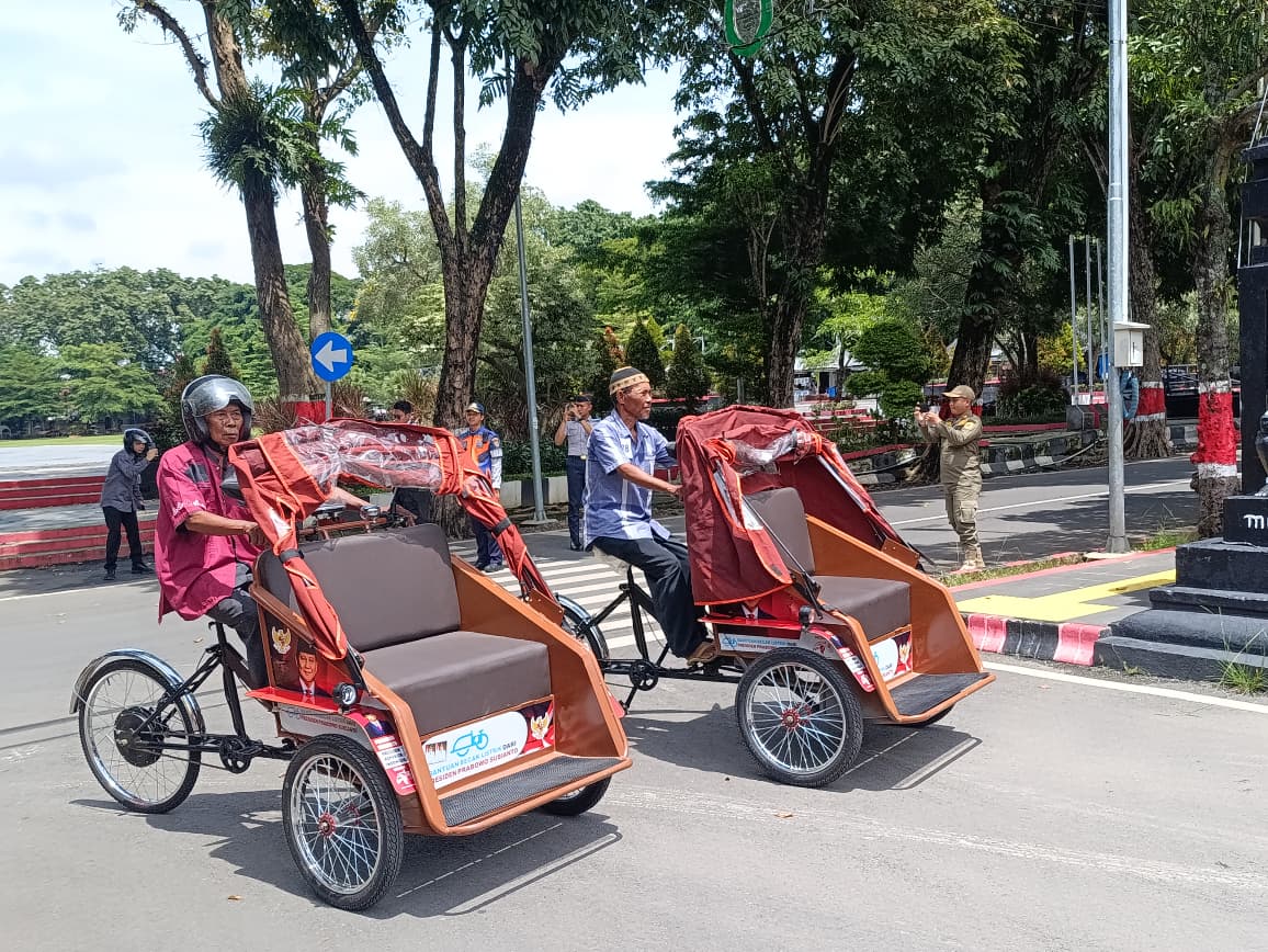 Para penerima bantuan becak listrik sedang menjajal becaknya.