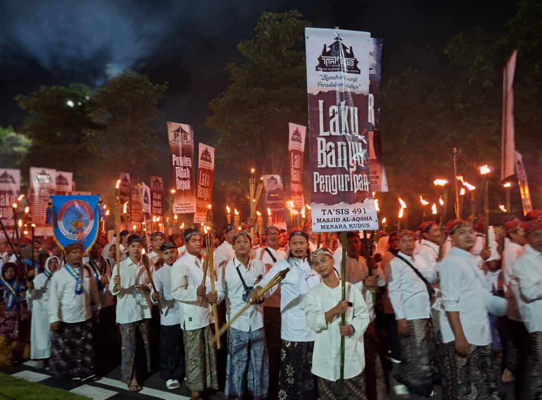 SERENTAK: Ribuan warga berjalan bersama membawa obor dan kendi berisi air dalam prosesi Laku Banyu Penguripan, Sabtu (3/1). (ANDIKA TRISNA SAPUTRA/RADAR KUDUS)