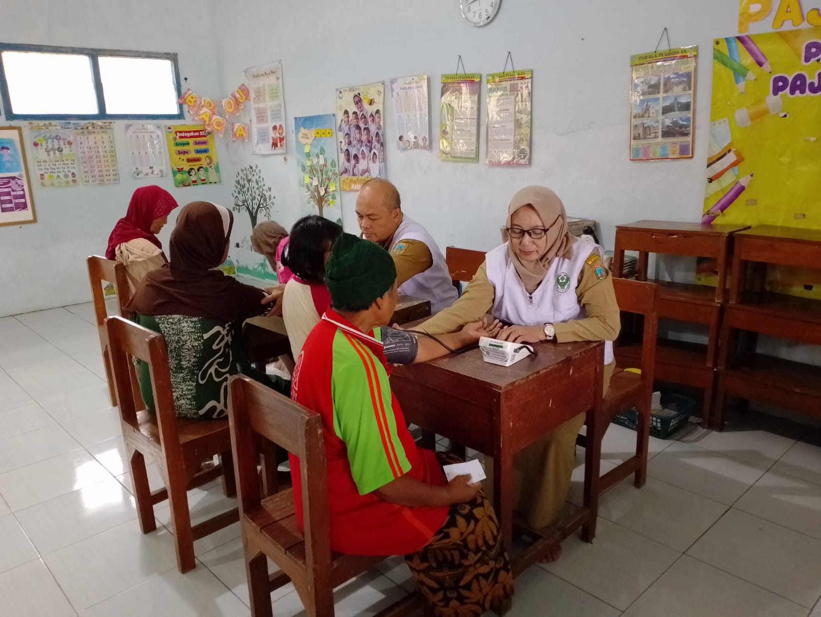 PEMERIKSAAN: Tim medis saat memeriksa warga terdampak banjir di Kecamatan Mejobo, Kudus, Rabu (14/1). (INDAH SUSANTI/RADAR KUDUS)