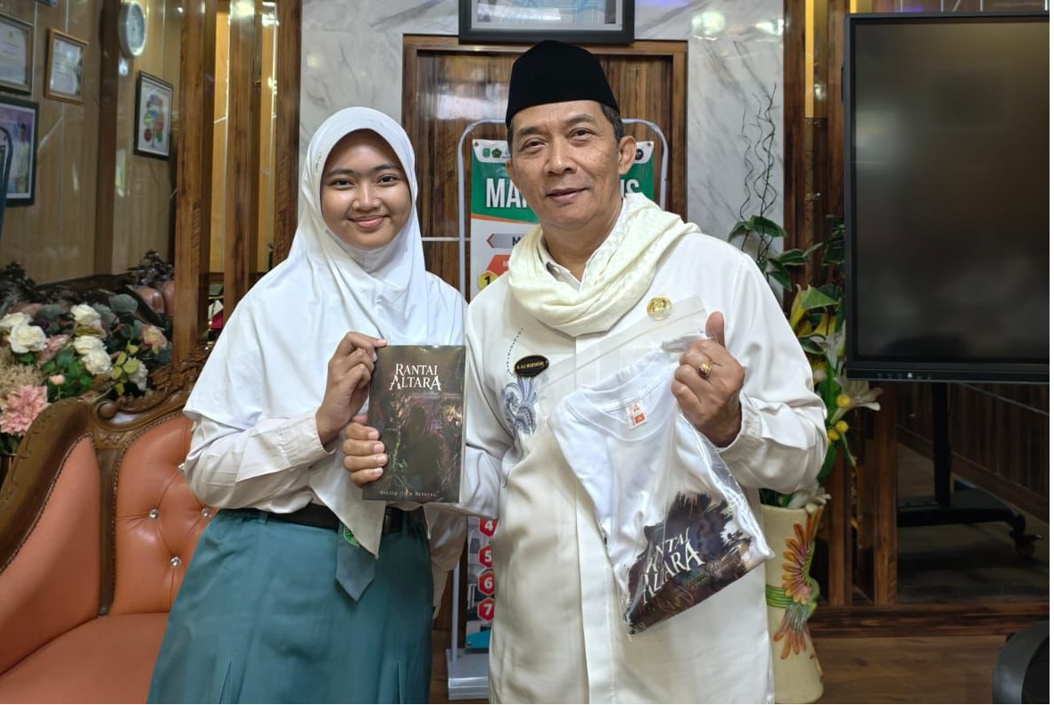 KARYA LITERASI: Siswa Bening Cita M. menunjukkan karya novel didampingi Kepala MAN 2 Kudus H. Ali Musyafak. (MAN 2 KUDUS UNTUK RADAR PATI)