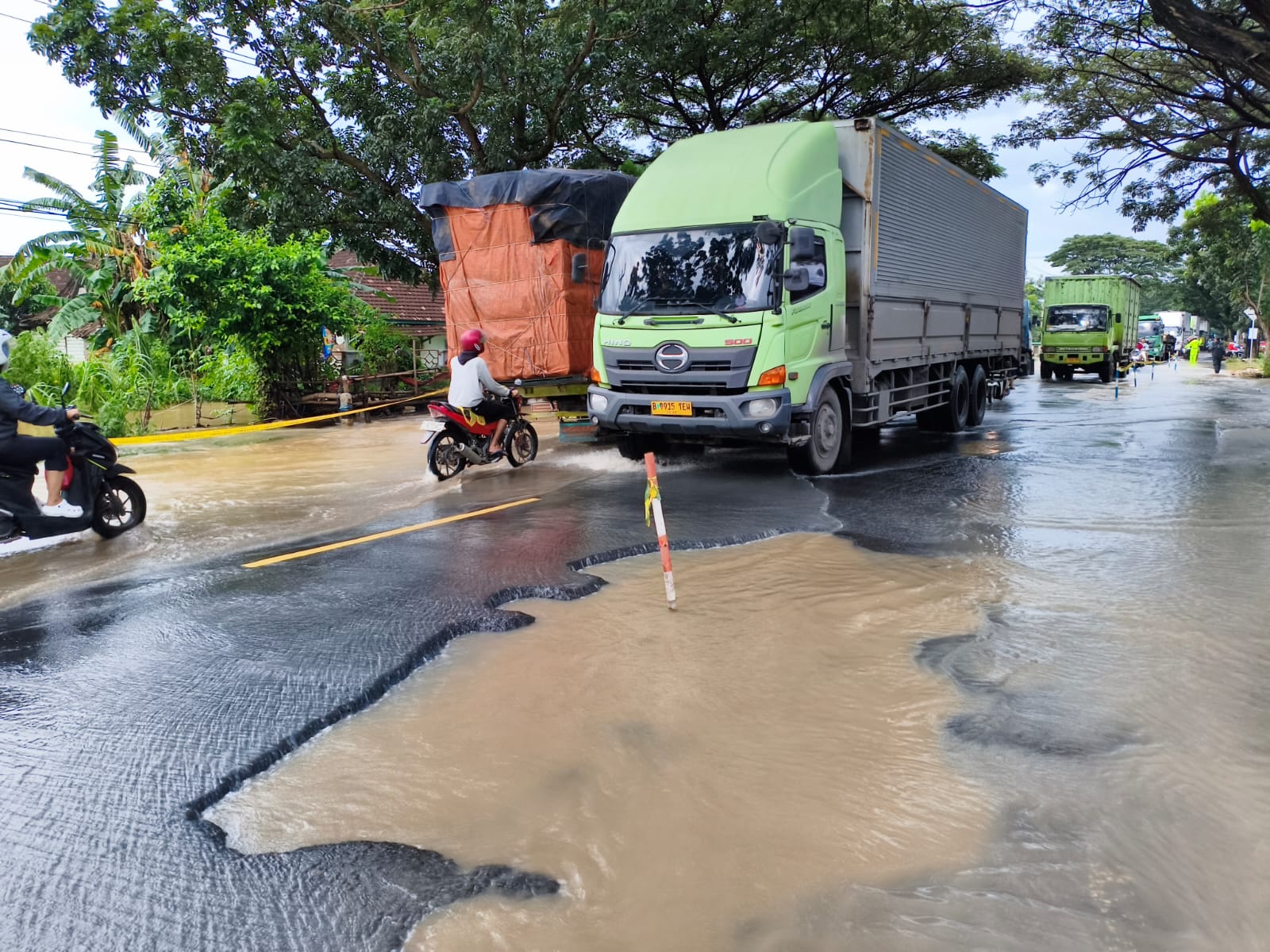 Sebuah truk melintas di depan lubang besar di Jalur Pantura Pati &ndash; Juwana di depan TL Widorokandang. (ACHMAD ULIL ALBAB/RADAR PATI)