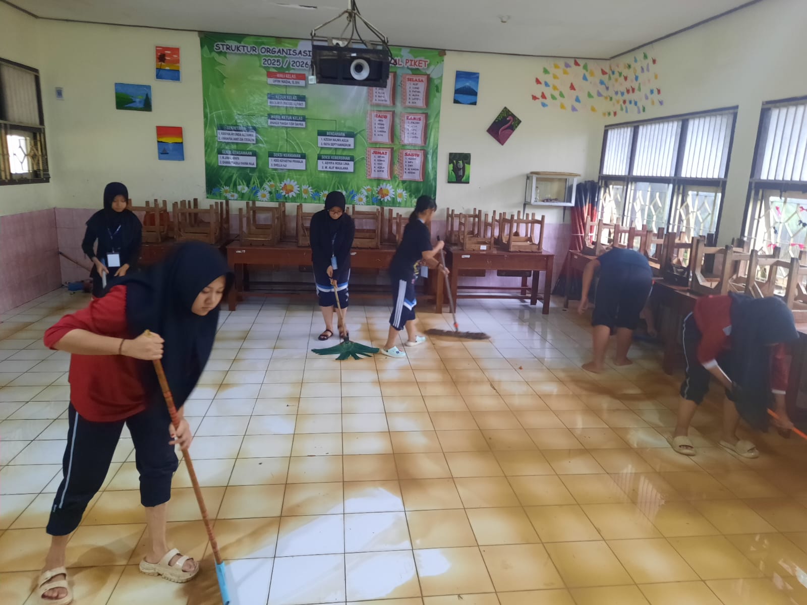 BERSIH-BERSIH:&nbsp;Siswa SMP 1 Kudus (kanan) membantu siswa SMP 2 Mejobo membersihkan ruang kelas yang terendam air lumpur karena kebanjiran. (INDAH SUSANTI/RADAR KUDUS) &nbsp;