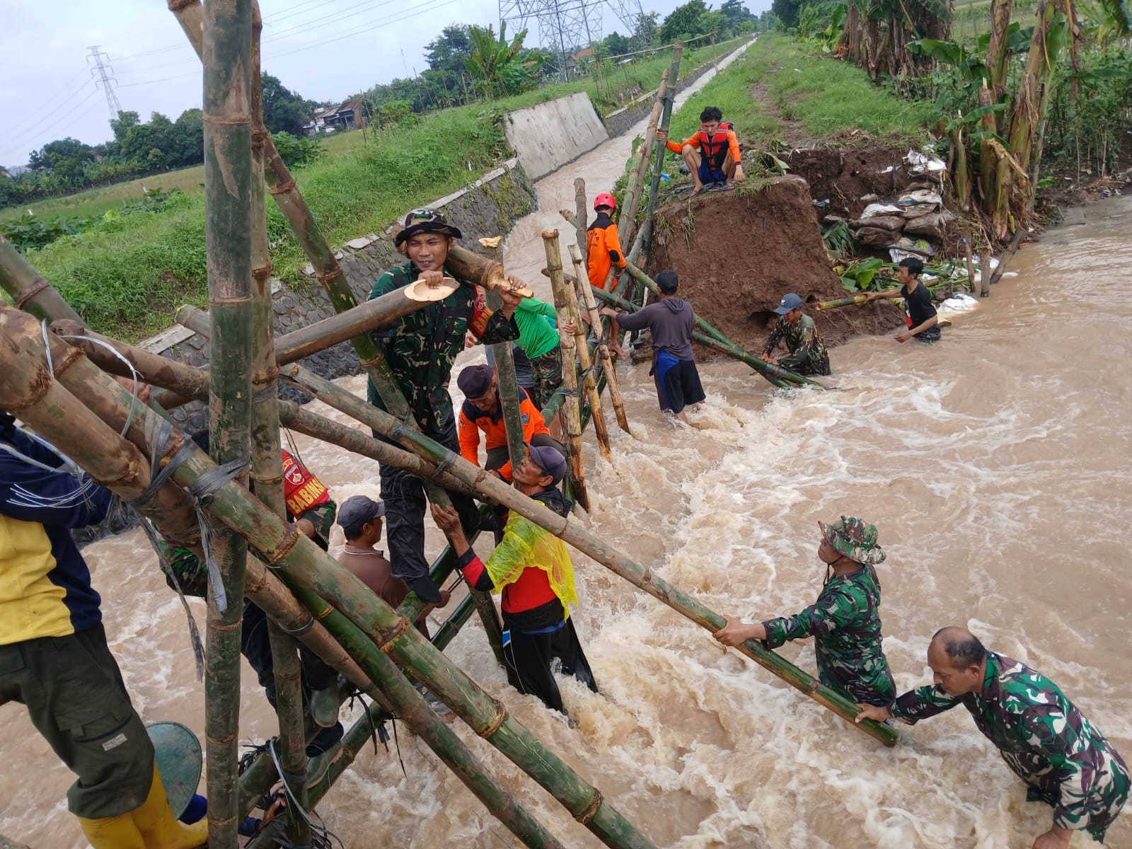 GOTONG ROYONG: Anggota TNI Kodim 0722/Kudus bersama warga bekerja sama memperbaiki tanggul irigasi yang jebol. (KODIM 0722/KUDUS UNTUK RADAR PATI)