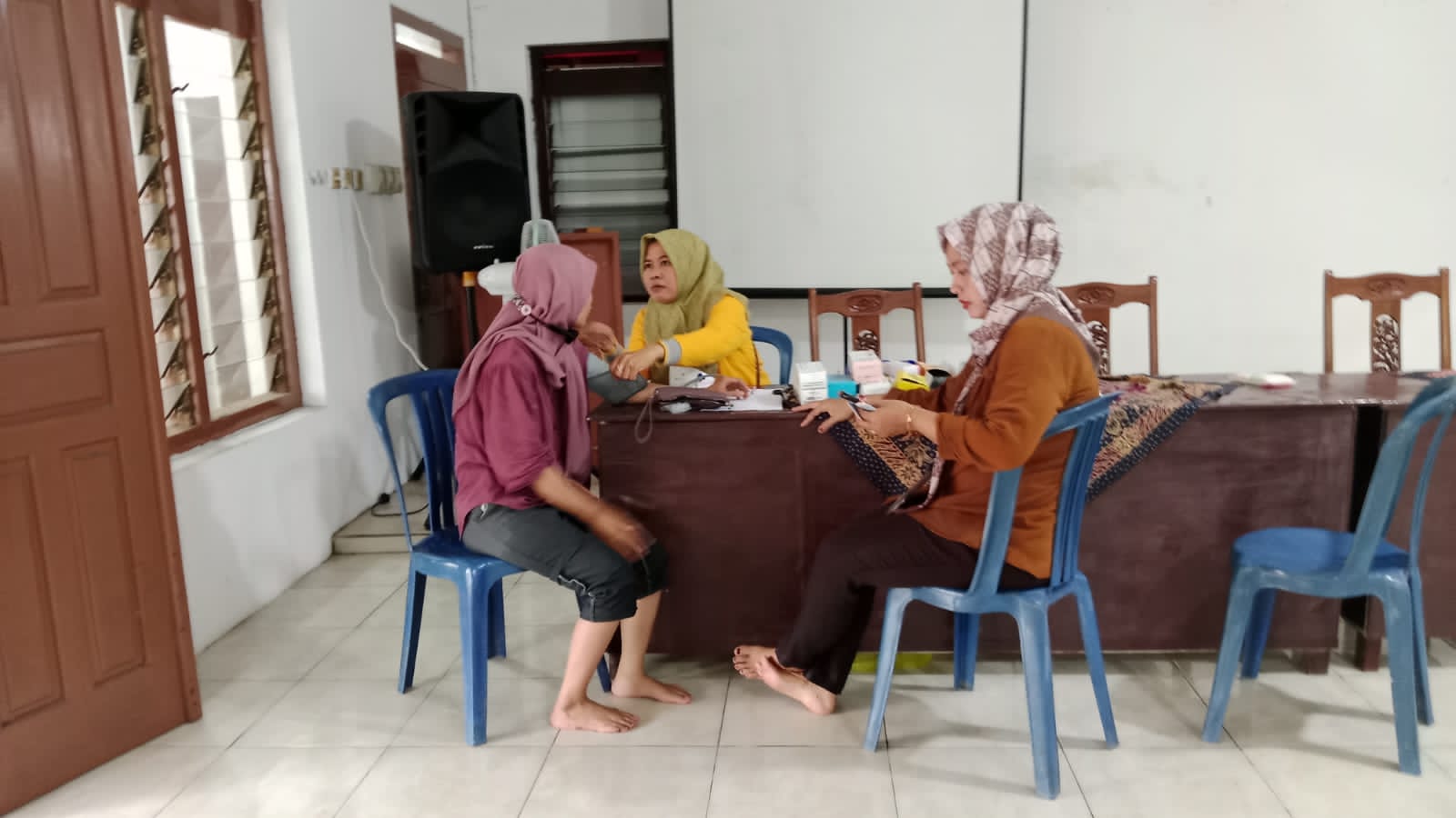 PERIKSA KESEHATAN: Tim medis dari Puskesmas saat memeriksa warga yang terdampak banjir.