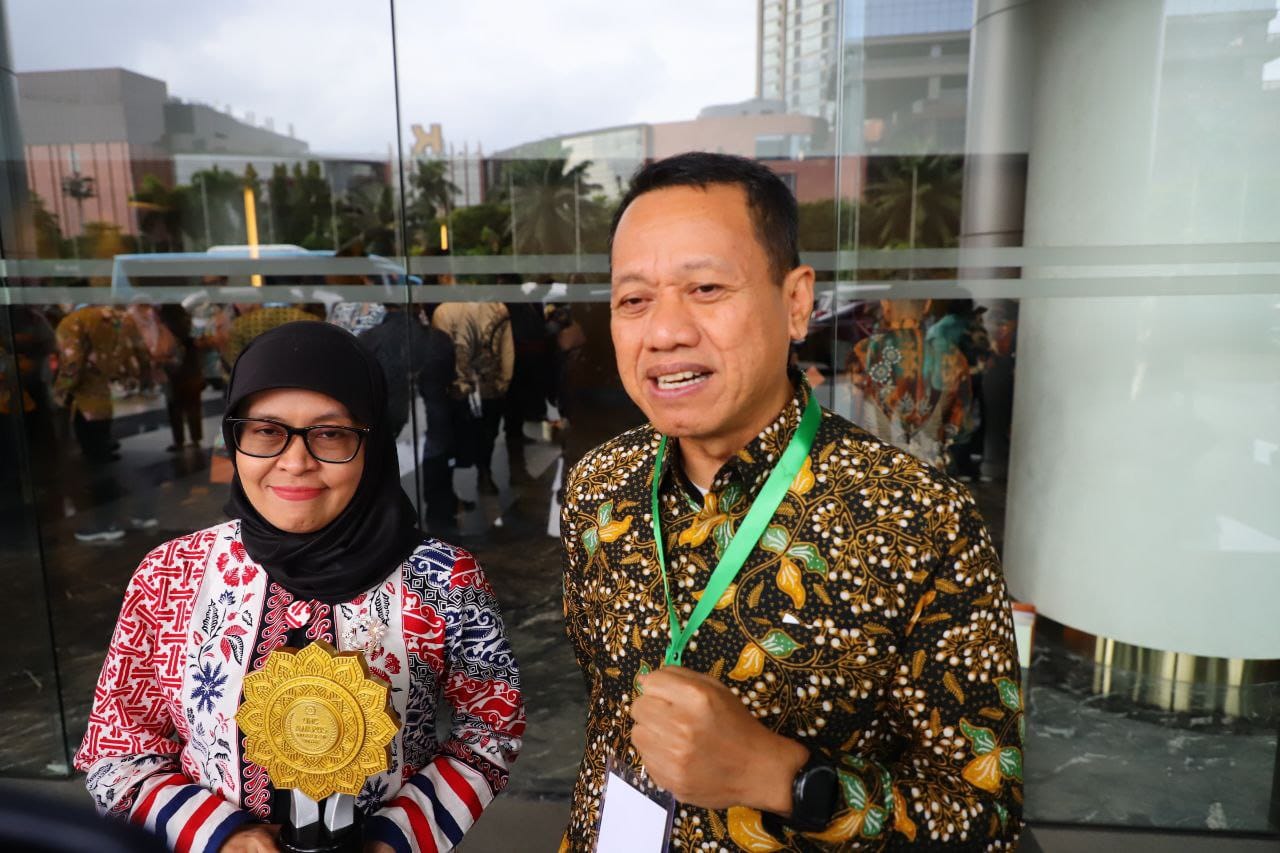 TERIMA PENGHARGAAN: Bupati Kudus Sam&rsquo;ani Intakoris (kanan) bersama kepala BPJS Kesehatan Cabang Kudus dr. Heni Riswanti menunjukkan piala penghargaan UHC Award 2026. (DINAS KOMINFO UNTUK RADAR PATI )
