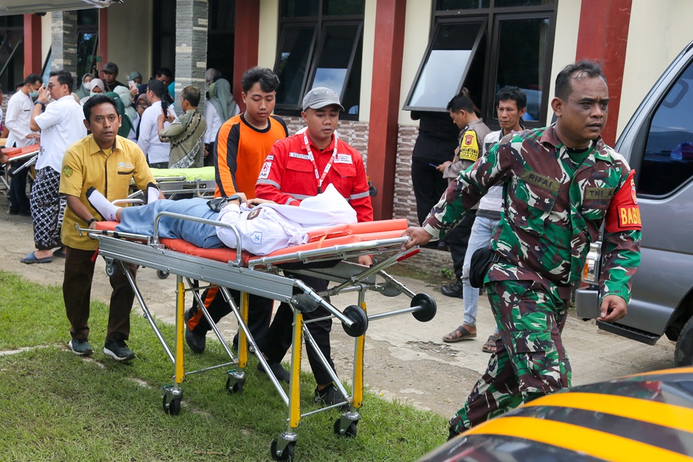 UPAYA PENANGANAN: Tim medis dan TNI mengevakusasi siswa yang mengalami dugaan keracunan MBG.