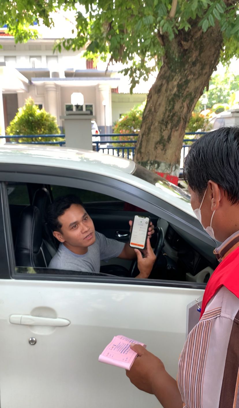 DIGITALISASI: jukir saat menunjukkan QRIS ke pengguna parkir di Alun-Alun Purwodadi.