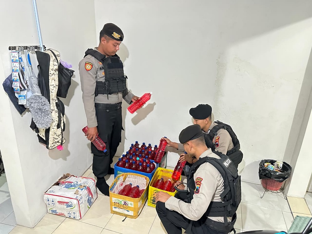 OPERASI MIRAS: Petugas kepolisian menunjukkan barang bukti minuman keras hasil penertiban. (POLRES KUDUS UNTUK RADAR PATI)