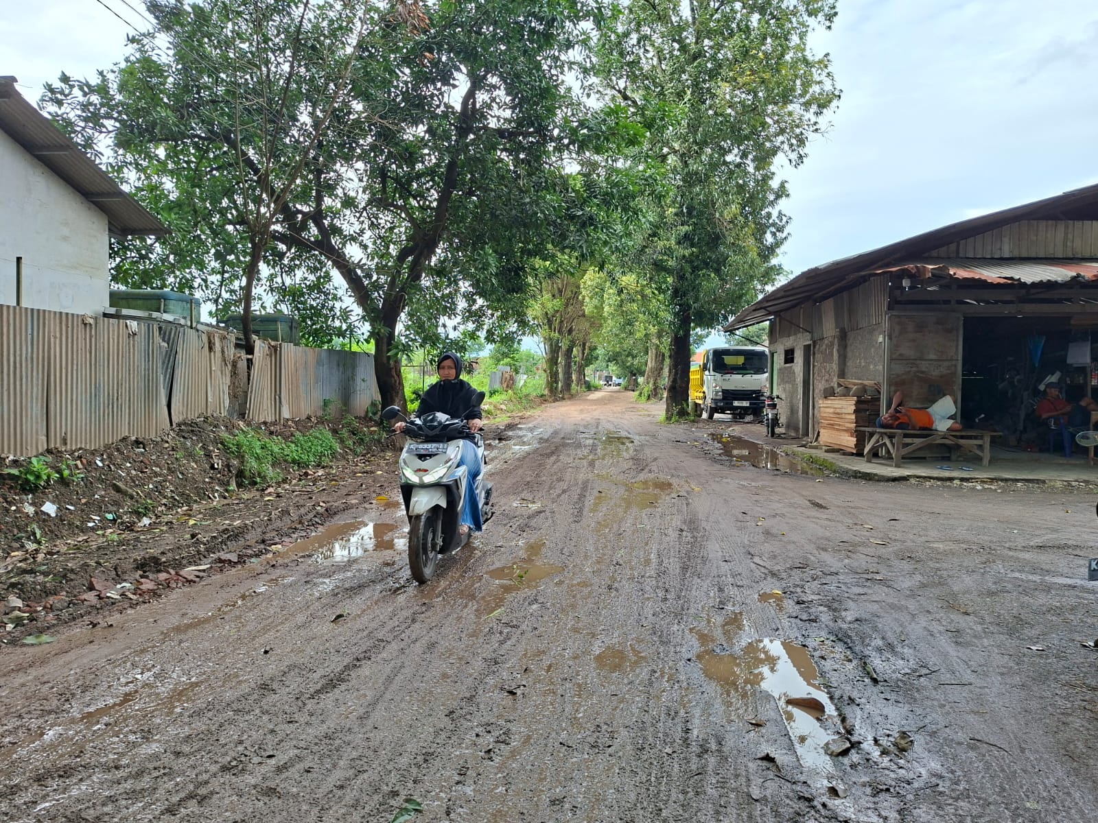  BECEK: Pengendara melintas di Jalan Desa Peganjaran, Bae, yang berlumpur dan tergenang air, Senin (23/2). (ANDIKA TRISNA SAPUTRA/RADAR PATI)