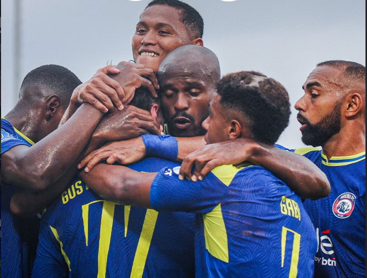 PemainArema FC saling berpelukan usai berhasil memenangkan laga