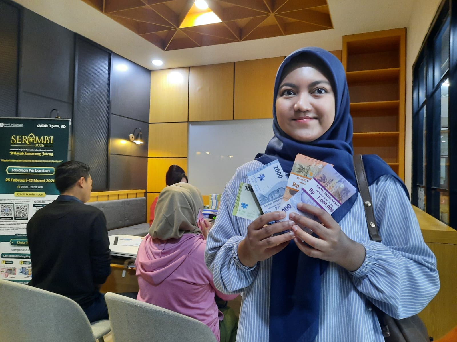 TUKAR UANG: Sri Handayani memperlihatkan pecahan uang baru usai menukar di Bank Jateng Cabang Kudus. //INDAH SUSANTI/RADAR PATI  