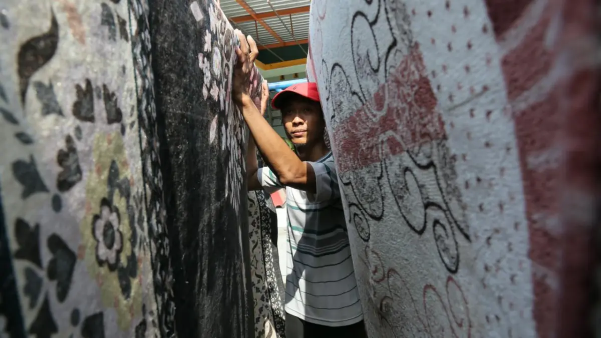 MEMBELUDAK: Pekerja menjemur karpet yang telah di cuci di Bekti Londri Desa Garung Lor. (GALIH ERLAMBANG W/ RADAR PATI)