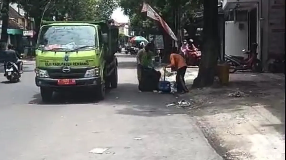 DISISIR: Petugas kebersihan DLH Rembang membersihkan sampah plastik hingga kertas saat acara pawai kirab larung sesaji yang melintas di pantura dan protokol, Sabtu lalu (28/3). (WISNU AJI/RADAR PATI)
