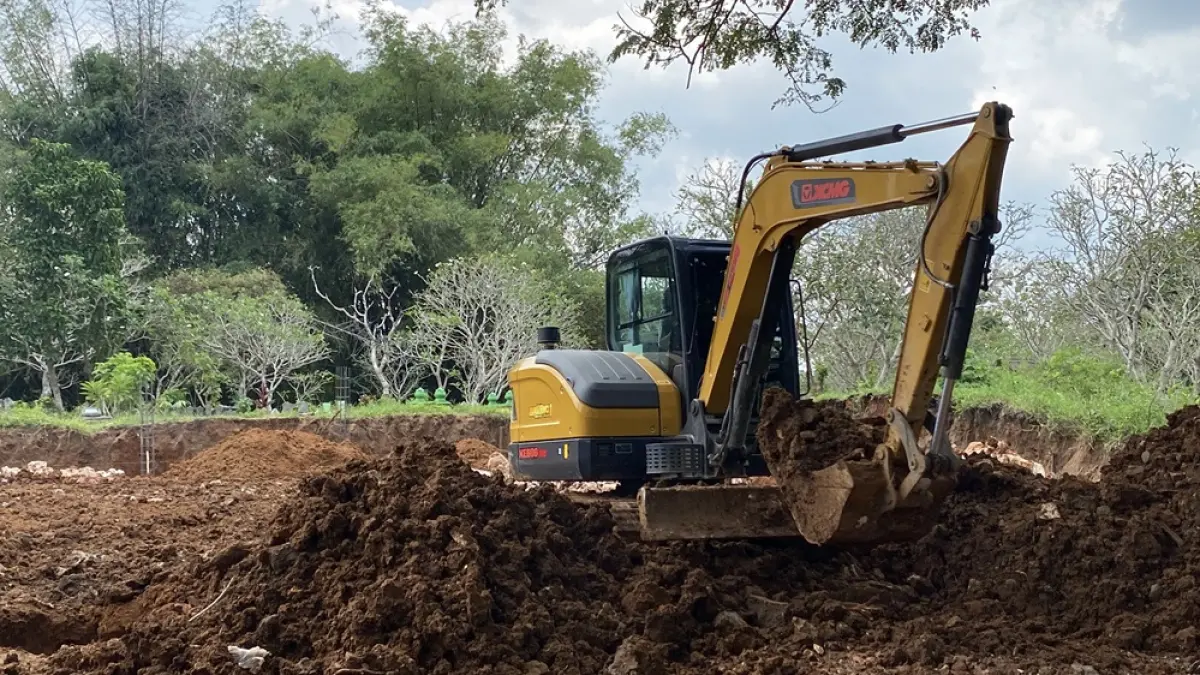PEMBANGUNAN: Alat berat eskavator melakukan pengurukan di lahan makam Desa Tegalgunung yang akan dibangun koperasi merah putih.  (ARIF FAKHRIAN KHALIM/RADAR PATI)
