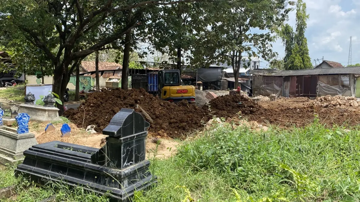 PEMBANGUNAN: Alat berat eskavator melakukan pengurukan di lahan makam Desa Tegalgunung yang akan dibangun koperasi merah putih.  (ARIF FAKHRIAN KHALIM/RADAR PATI)
