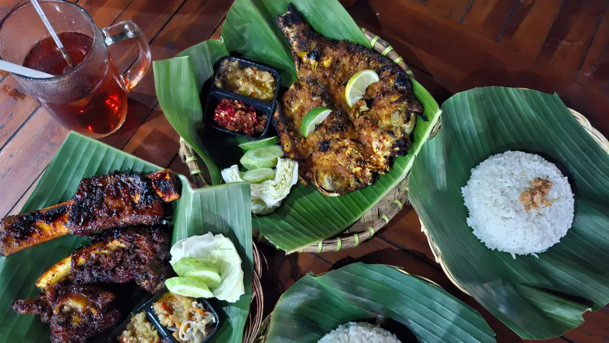 SAJIKAN: Karyawan menyajikan menu ikan bakar dan iga bakar untuk diantarkan ke meja pengunjung. (ANDIKA TRISNA SAPUTRA/RADAR PATI)