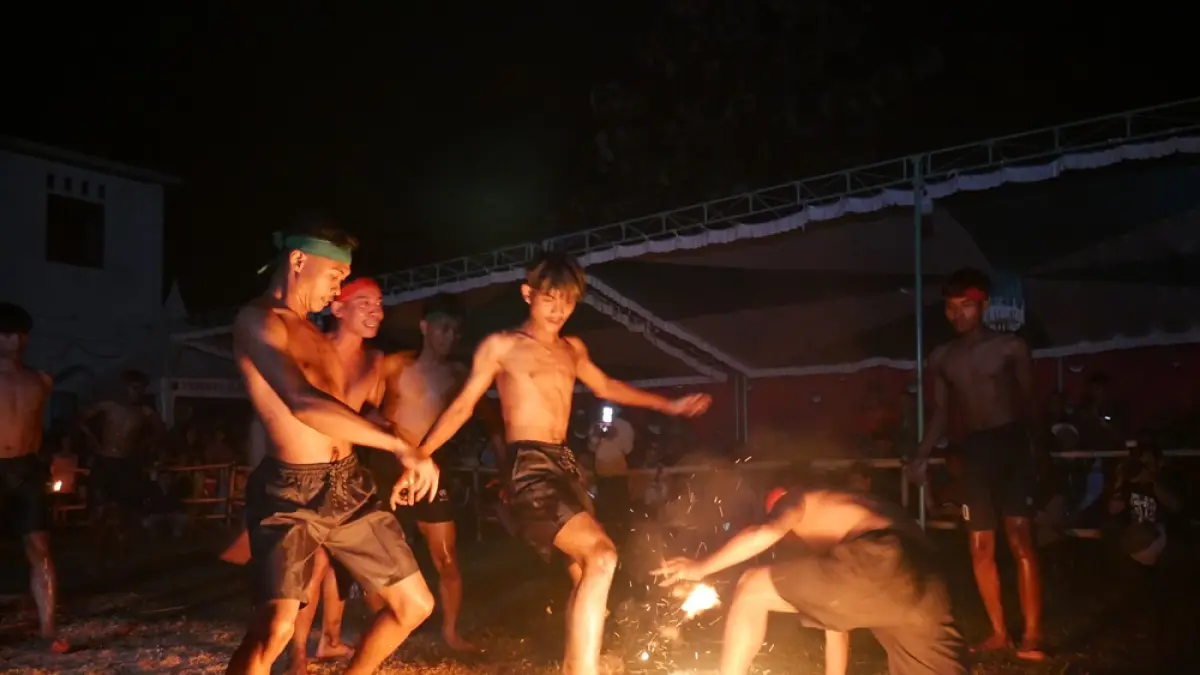 MENGHIBUR: Para pemain sepakbola api tengah menampilkan atraksi wisata pada Selasa (21/4) malam, di Lapangan Balai Desa Kawak, Pakis Aji, Jepara. (FIKRI THOHARUDIN/RADAR PATI)