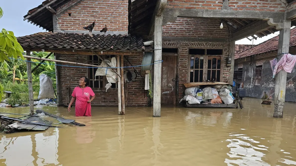 AYAMNYA NAIK GENTING: Warga Desa Ketitangwetan, Batangan, Pati, beraktivitas di tengah banjir di desanya. (ANDRE FAIDHIL FALAH/RADAR PAT)