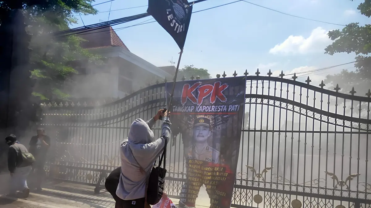 DIBAKAR: Pengunjukrasa membakar baner bergambar Kapolresta Pati di depan Pendapa Pati. (ANDRE FAIDHIL FALAH/RADAR PAT)
