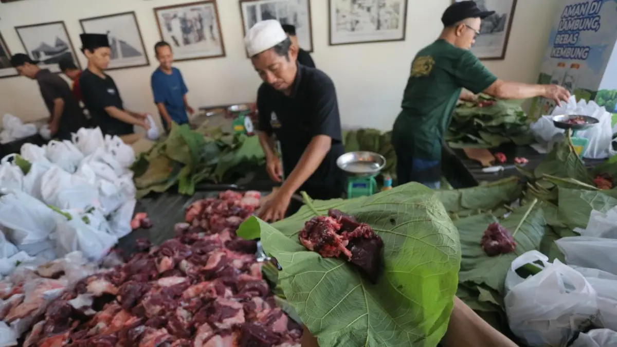 SEGERA DIDISTRIBUSIKAN: Perewang membungkus daging hewan kurban dengan daun jati. GALIH ERLAMBANG W/ Radar PATI)