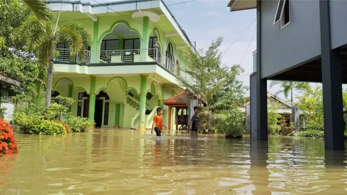 BERTAHAN: Warga Tunggulsari, Tayu beraktifitas di tengah banjir belum lama ini. (ANDRE FAIDHIL FALAH/RADAR PATI)