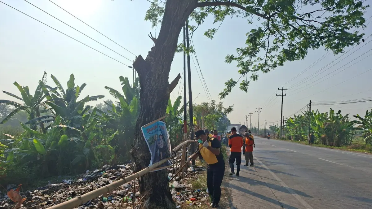 SAMPAH: Polsek Gubug bersama DLH Grobogan saat melakukan pembersihan sampah di sepanjang Jalan Purwodadi-Semarang.