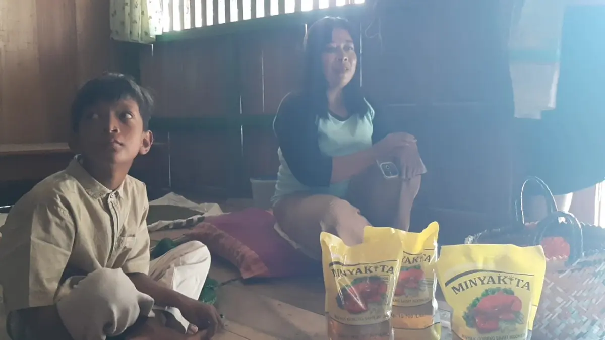BERBAU – Warga Desa Penadaran, Kecamatan Gubug menunjukan bantuan Minyakita yang diduga berbau solar warga mengembalikan bantuan tersebut. (SIROJUL MUNIR/RADAR PATI)